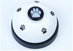 Pawlio Paw Press Training Bell with a white base and a metal bell for dog training and communication.