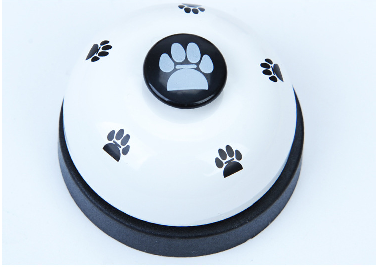 Pawlio Paw Press Training Bell with a white base and a metal bell for dog training and communication.